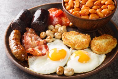 Tam İrlanda usulü puding, yumurta, fasulye, sosis, domuz pastırması, haşhaş, masada domates kapağı. Yatay