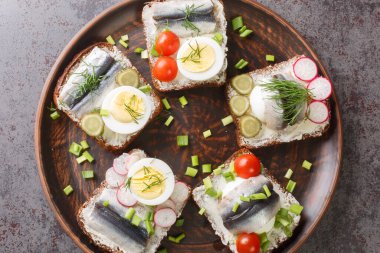Estonya usulü lezzetli kiluvoileib sandviçi, masada balık, yumurta ve tereyağı ile yakın plan. Yukarıdan yatay üst görünüm