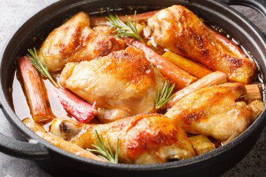 Tavuklu rhubarb, biberiye ve beyaz şarapla yakın plan bir tavada masada. yatay