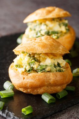 Tatil profiterolleri için aperatifler. Masanın üzerinde yumurta salatası var. dikey