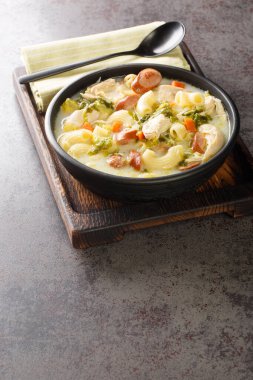 Sebzeli Filipinli Tavuk Makarna Çorbası, tavuk ve dirsek makarnası masanın üstünde yakın plan. Dikey