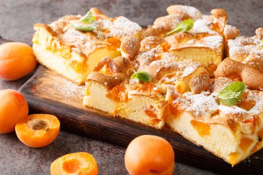 Kayısı soslu sünger turtası ve taze nane şekeri masaya yakın, ahşap bir tahta üzerinde. Yatay