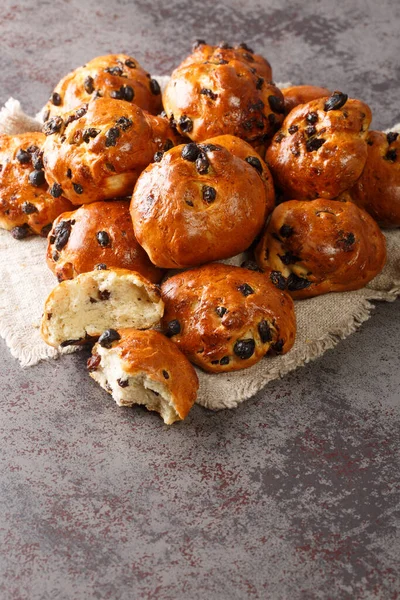Krentenbollen Hollanda usulü taze pişmiş üzümlü üzümlü sarma bir masaya yakın çekim. Dikey