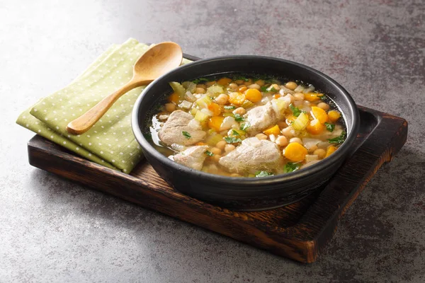 İtalyan domuz eti ve sebzeli nohut çorbası masanın üzerindeki kaseye yakın. yatay