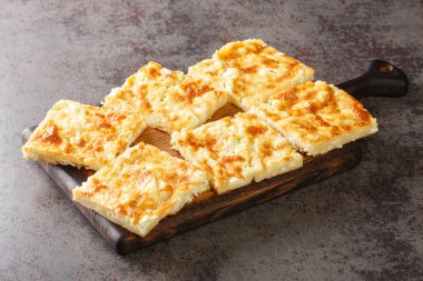 Alevropita Yunan turtası, masanın üzerindeki tahta tahtaya yakın plan peynir serpiştirilmiş ince bir hamurdan oluşuyor. Yatay