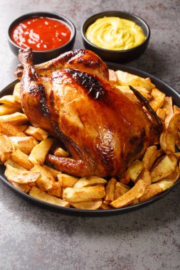 Şenlikli ızgara tavuk, kızarmış patates, hardal ve ketçapla birlikte masanın üstünde. Dikey