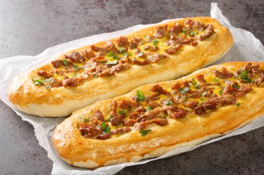 Pastrmalija Makedon Pizzası geleneksel bir favoridir ve masanın üzerindeki parşömenin üzerinde domuz eti, yumurta ve lezzetli pizza hamuru parçacıkları ile yapılır. Yatay