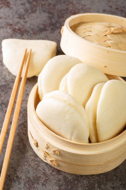 Masadaki bambu sepetinin üzerine buğulanmış Bao Çörekleri yaprağını kapat. Dikey