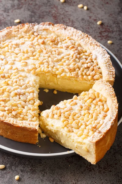 Traditional Tuscany pastry Italian cake torta della nonna or grandmother\'s cake closeup in the plate on the table. Vertica