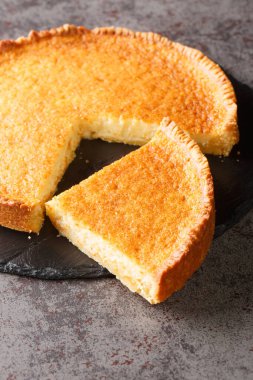 American Southern Buttermilk Pie close-up in a slate plate on the table. Vertica
