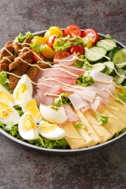 Güzel ve nefis yumurtalı Şef Salatası. jambon, peynir, taze domates, salatalık ve baharatlı kızarmış ekmekler masanın üzerindeki tabağa yakın. Dikey