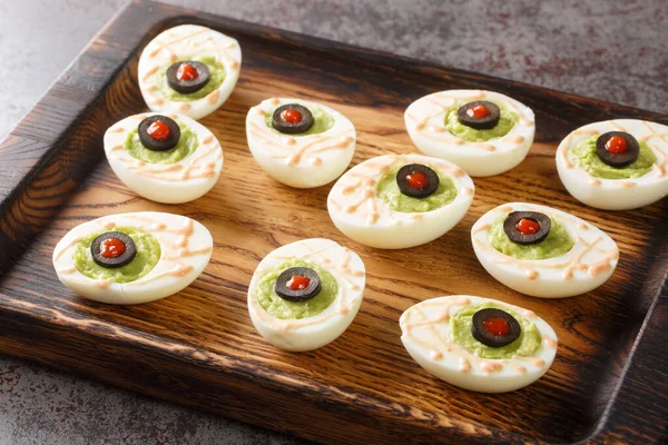 Delicious Deviled Eggs Stuffed Guacamole Olives Close Wooden Tray Table — Zdjęcie stockowe