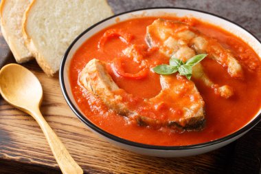 Thick hearty Soup with carp steak, vegetables and paprika close-up in a bowl on the table. Horizonta
