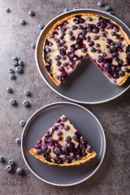 Sliced Mustikkapiirakka Finnish Blueberry Pie close-up in a plate on a table. Vertical top view from abov