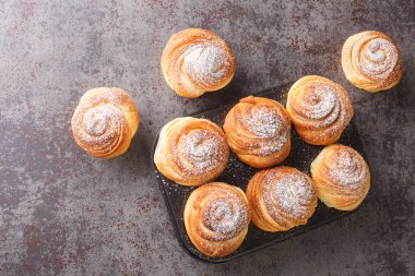 cruffins easter spring pastries, muffin and croissant roll on a dark background, close-up. Horizontal top view from abov