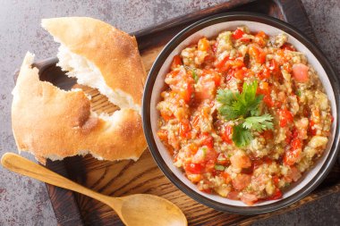 Vegetarian caviar salad of eggplant, tomatoes, bell peppers, garlic seasoned with olive oil close-up in a bowl on the table. Horizontal top view from abov