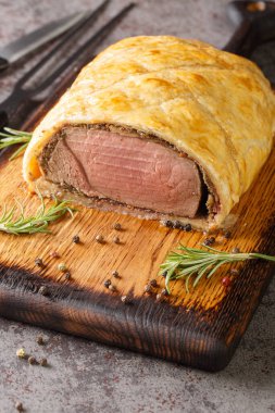 Homemade Christmas Beef Wellington with a Pastry Crust closeup on rustic wooden board on the table. Vertica