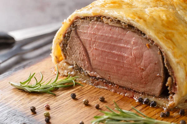 Christmas Beef Wellington with a Pastry Crust closeup on rustic wooden board. Horizonta