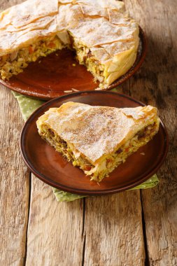 Fresh baked traditional Moroccan Pastilla or chicken bastilla closeup in the plate on the table. Vertica