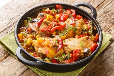 Ivory Coast food Chicken slowly stewed with vegetables and herbs close-up in a frying pan on the table. Horizonta
