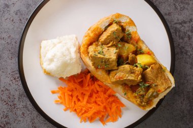 traditional durban mutton bunny chow closeup on plate on the table. Horizontal top view from abov