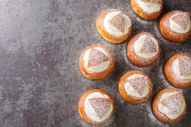 Masanın üzerinde krem şantili ve kremalı çörekler var. Yukarıdan yatay üst görünüm