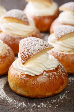 Geleneksel kış tatlı Semla semlor 'u ya da kakule aromalı fast-lagsbulle, badem ezmesi ve krem şanti ile kaplanmış. Dikey