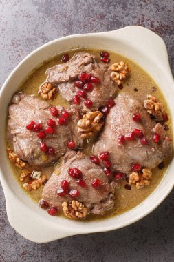 Fesenjan İran nar cevizi ve tavuk yahnisini yakın plan bir tabakta masanın üzerinde. Yukarıdan dikey üst görünüm