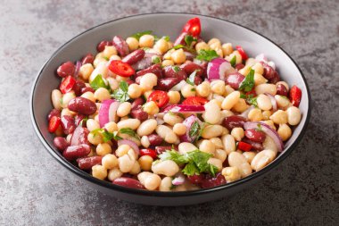 Masadaki kasede üç fasulyeli vejetaryen salatası. Yatay
