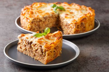 Peynirli fırınlanmış spagetti turtası, kıymalı, baharatlı ve domates soslu masaya yakın. Yatay