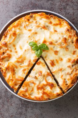 Köfteli spagetti turtası, peynir, domates sosu masanın üzerindeki tabağa yakın. Yukarıdan dikey üst görünüm