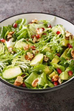 Brüksel lahanası, Avokado, ceviz ve marul salatası masadaki kasede yakın plan. Dikey