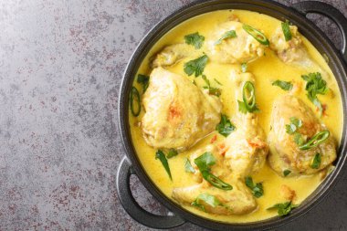 Hindistan cevizi soslu tavuk parçaları, baharat, domates, sarımsak, soğan ve kırmızı biberli kızartma tavasında yakın plan. Yukarıdan yatay üst görünüm