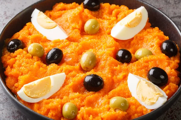辣胡萝卜泥与煮熟的鸡蛋和橄榄一起放在桌上的碗里 横向A — 图库照片