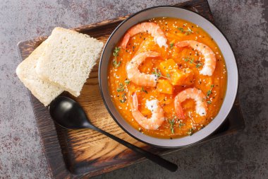 Karidesli balkabağı sebze çorbası, susam tohumu ve masadaki ahşap tepside kekik yakın plan. Yukarıdan yatay üst görünüm