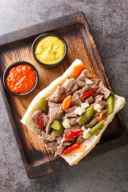 Masadaki ahşap tepside Chicago usulü İtalyan biftekli sandviç. Yukarıdan dikey üst görünüm