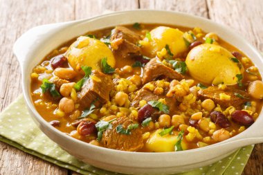 Geleneksel Yahudi Cholent Hamin ana yemeğinin yakın çekimi, masada patates, fasulye ve kahverengi yumurtalarla yavaşça pişirilmiş biftek. Yatay