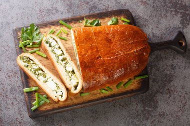 Taze bitkilerle dolu maya keki. Masanın üzerindeki tahta tahtaya yumurta yakın plan. Yukarıdan yatay üst görünüm