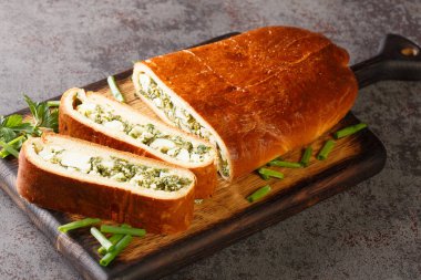 Masadaki tahtanın üzerinde yumurta ve bitkilerle nefis pişmiş köfte. Yatay