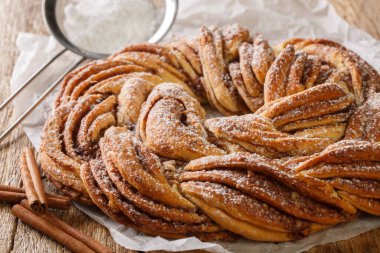 Kuzey Avrupa 'da kringle ya da simit geleneksel Noel tatlısı. Tahta masadaki kağıdın üzerinde tarçın var. Yatay