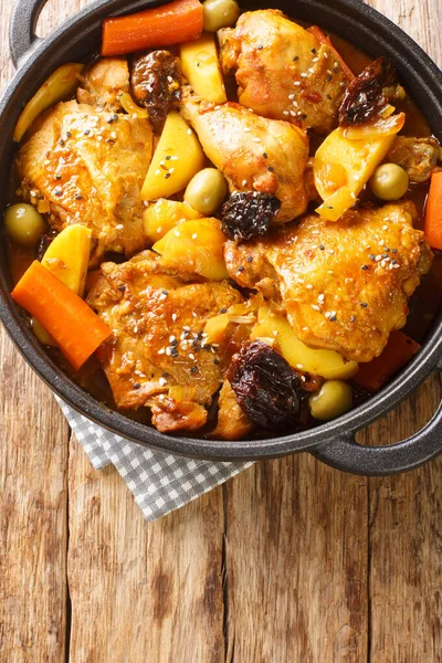 Gallo en chicha is a traditional chicken dish that is popular in El Salvador, as well as in other Central American countries closeup on the pan on the wooden table. Vertical top view from abov