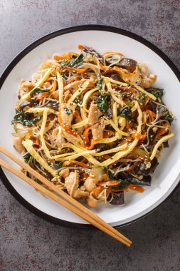 Japchae ya da kızarmış Kore vermicelli erişteli sebzeli ve üstünde susam ezmesi olan domuz etli erişte. Yukarıdan dikey üst görünüm