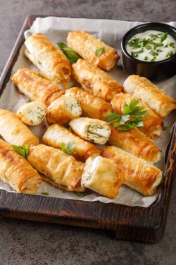 Sigara Boregi Türk Purosu Peynir ve otlarla doldurulmuş Rolls Royce tablonun üzerindeki tahta tahtaya yakın plan. Dikey