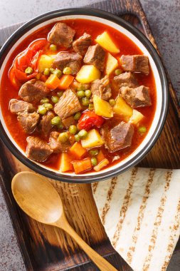 Orman kebabı mı? Masanın üzerindeki kasede bir sürü bezelye ve dilimlenmiş patates bulunan sulu bir et tabağı. Yukarıdan dikey üst görünüm