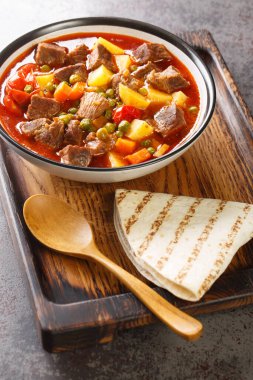 Orman kebabı mı? Masanın üzerindeki kasede bir sürü bezelye ve dilimlenmiş patates bulunan sulu bir et tabağı. Dikey