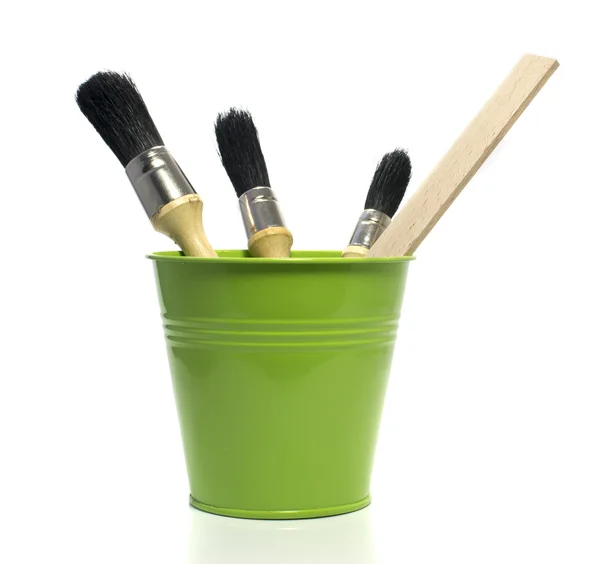 Green bucket with paint brushes — Stock Photo, Image