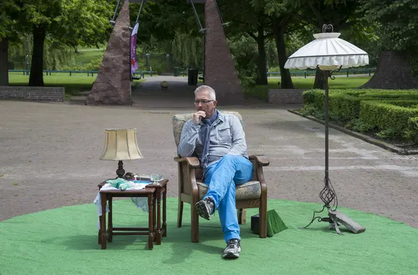 Om stând într-un parc pe scaun cu masă și lampă — Fotografie, imagine de stoc