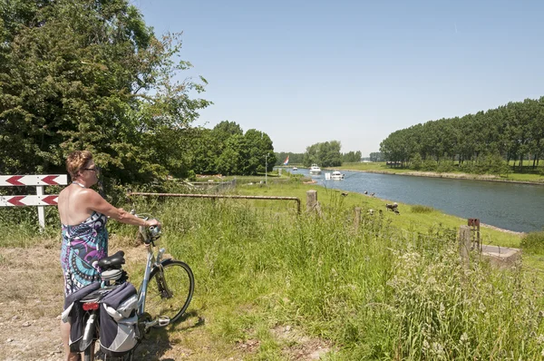 Mujer con bicicleta mirando el río — Foto de Stock