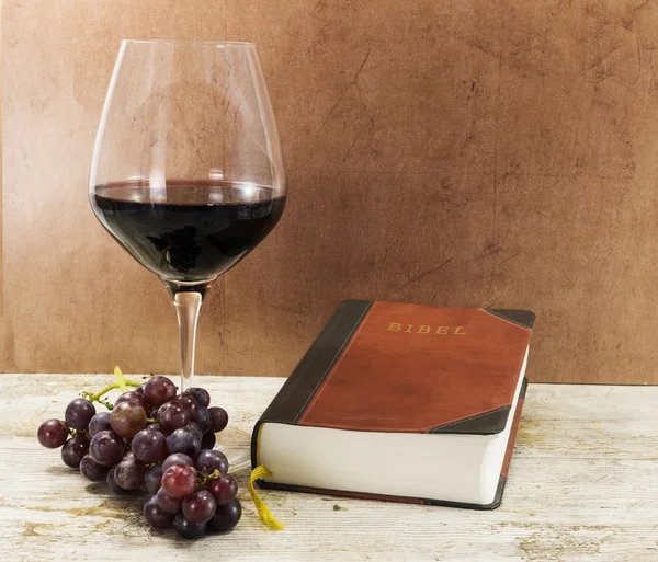 Libro viejo y vino tinto con uvas en la mesa — Foto de Stock