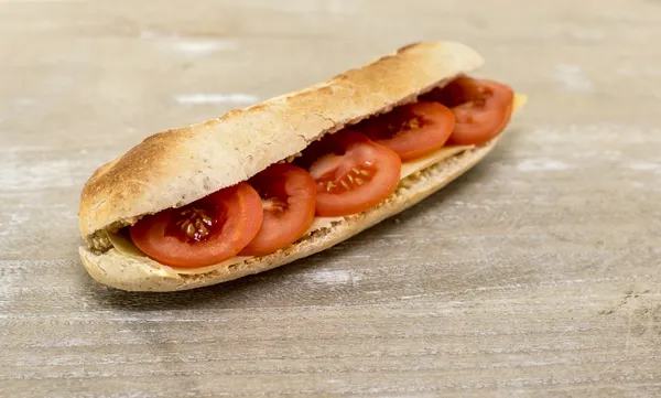 Färskt bröd ur ugnen med ost och tomat — Stockfoto